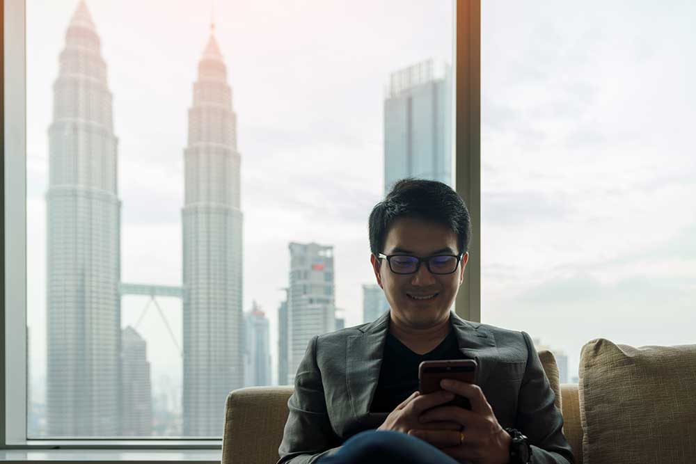 A middle aged male businessman using a smartphone in an office building