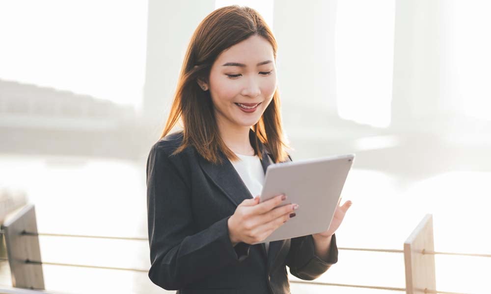 A young professional woman using tablet and smiling