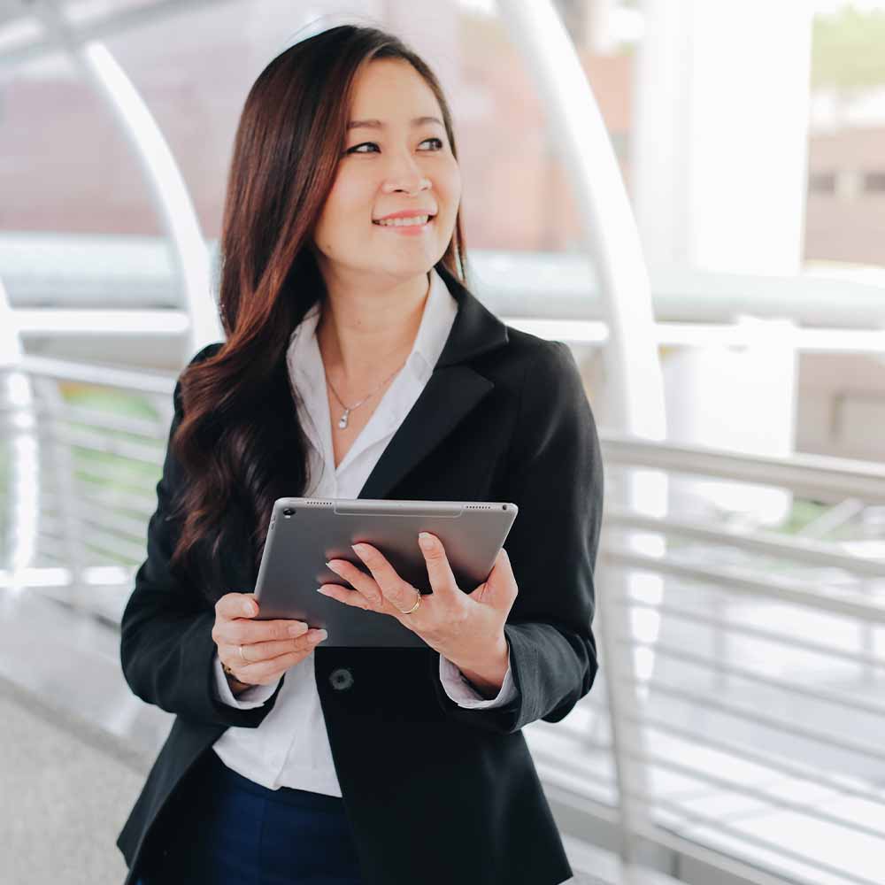 A young professional woman using tablet and smiling